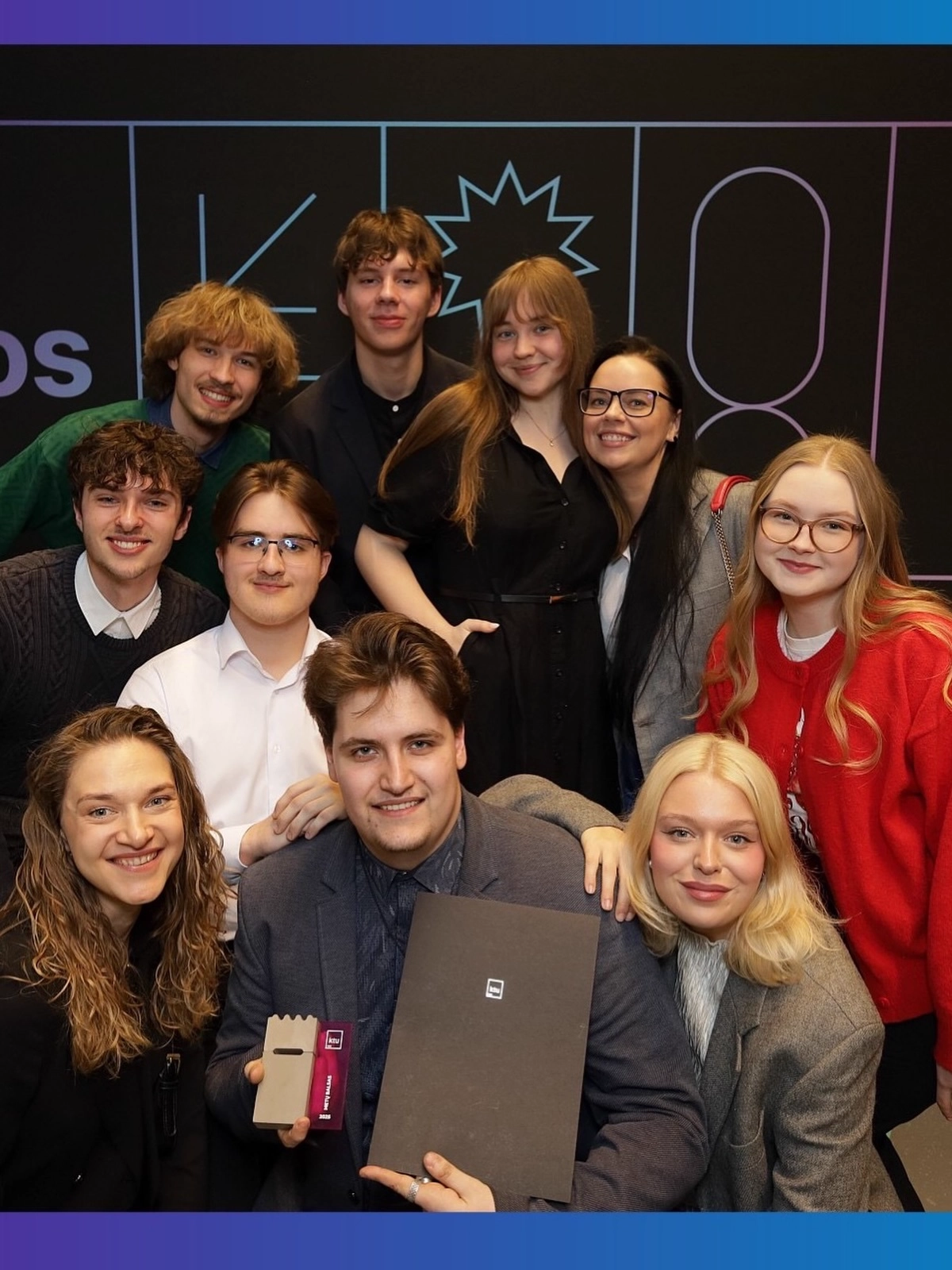 Dešimt laimingų choristų laikantys laimėtą metų balso statulėlę bei diplomą